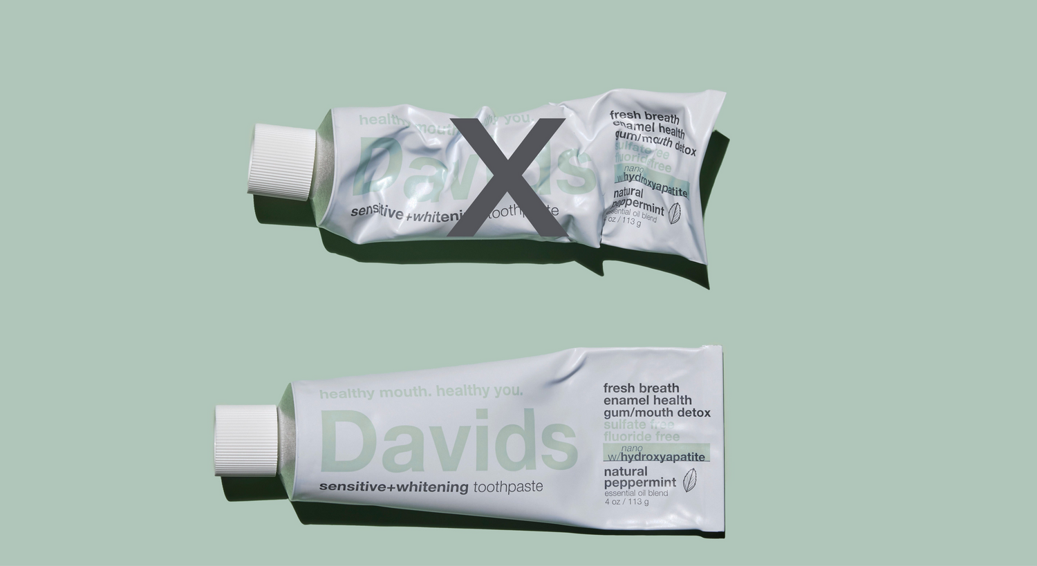 Crumpled vs. new Davids toothpaste tube on green background