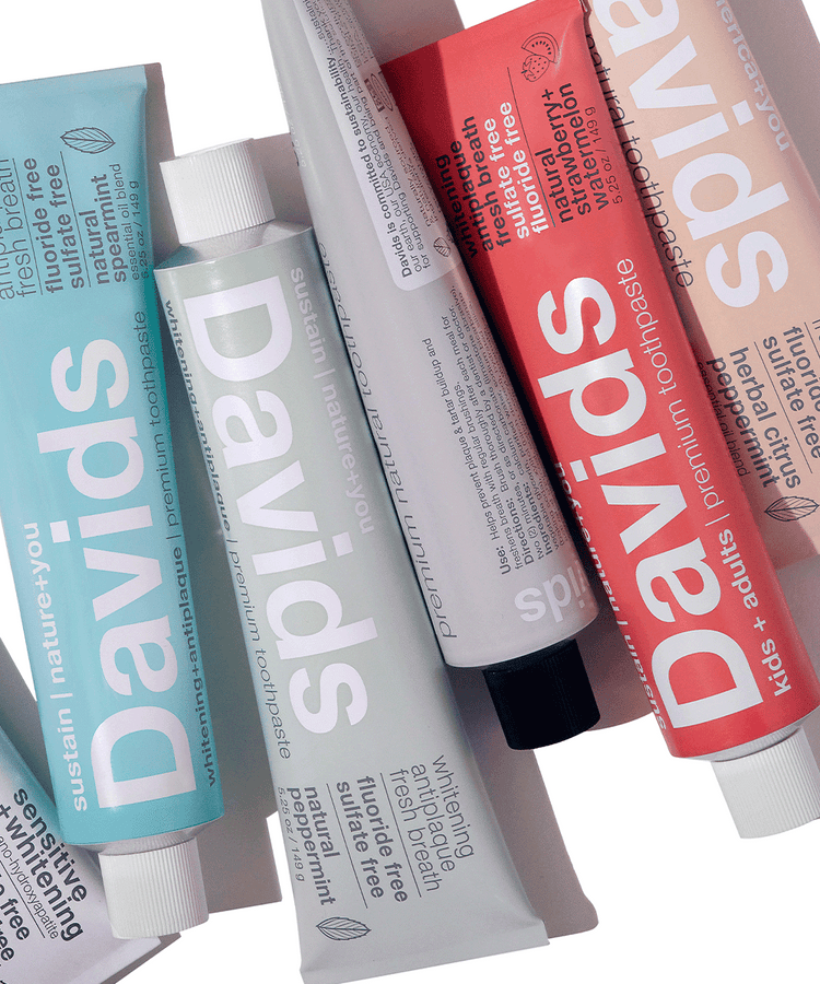 Assorted Davids toothpaste tubes in different colors and flavors arranged diagonally on a white background