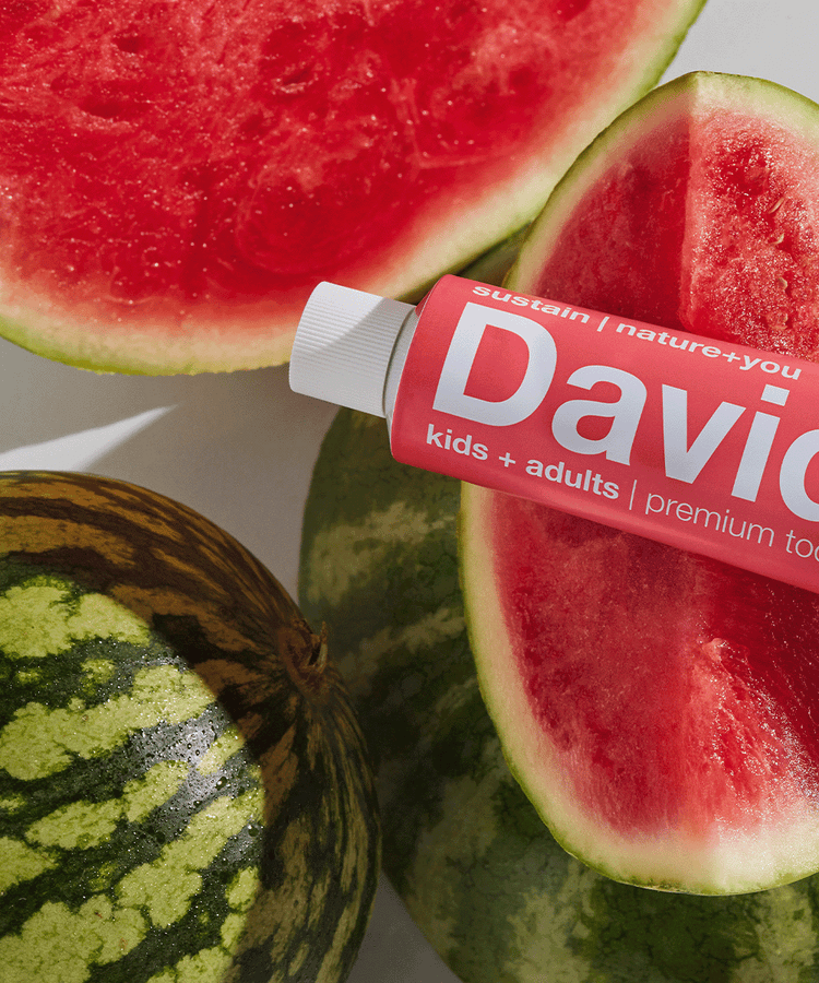 Davids kids and adults toothpaste in red tube placed on fresh watermelon slices